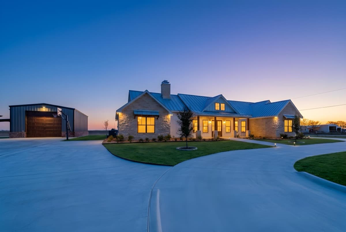 Custom stone farmhouse at twilight built by TKG Custom Homes in Seguin, Texas