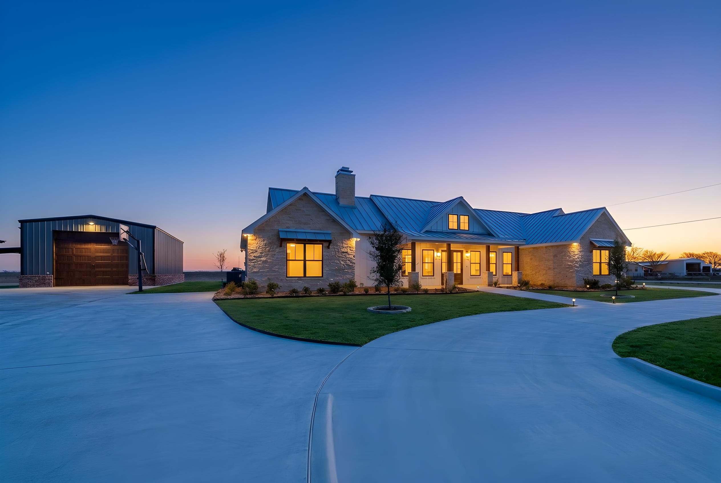 Custom stone farmhouse at twilight built by TKG Custom Homes in Seguin, Texas